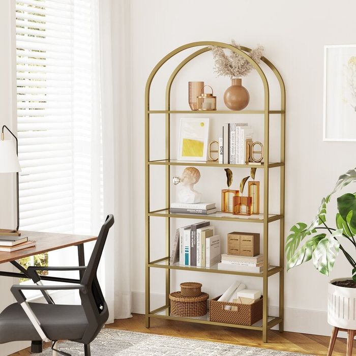 An elegant arched bookshelf adorned with decorative pieces and books, set in a cozy room designed for a sophisticated ambiance.
