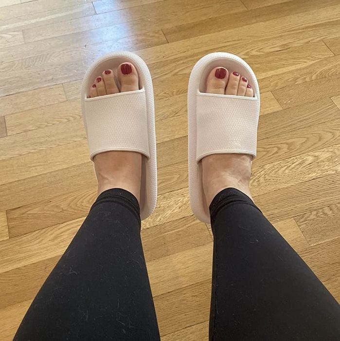 A reviewer wearing black leggings paired with tan open-toed slippers