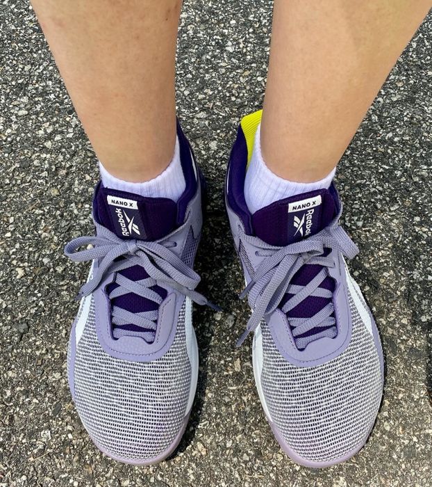 A reviewer wears the same style of shoe in purple and gray colors.