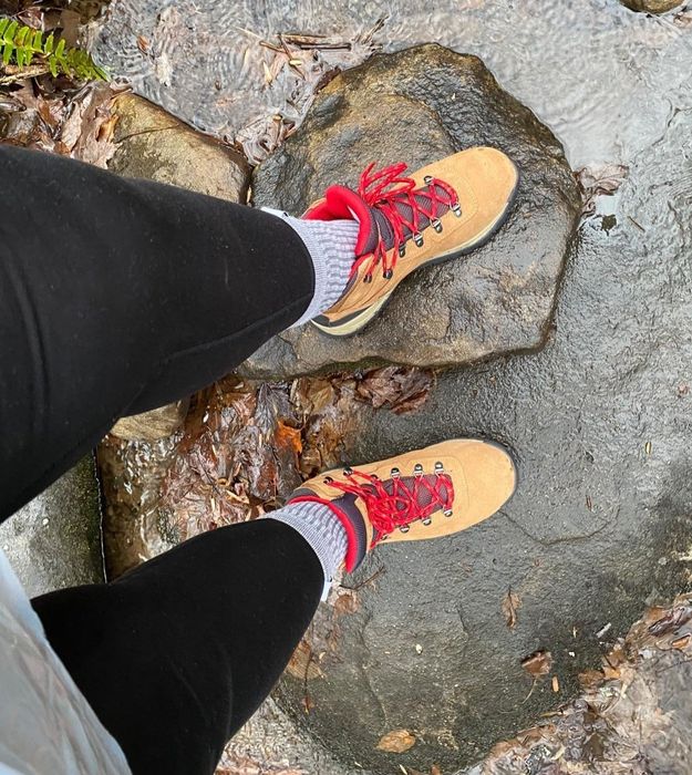 Reviewer sports tan boots while hiking along a trail
