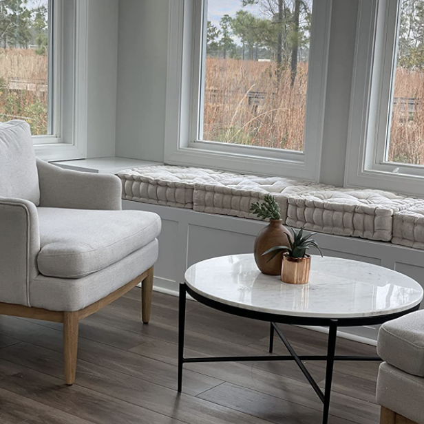 A reviewer's living room with an assortment of cushions neatly arranged on a wooden shelf below.