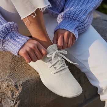 model wearing white Allbirds sneakers