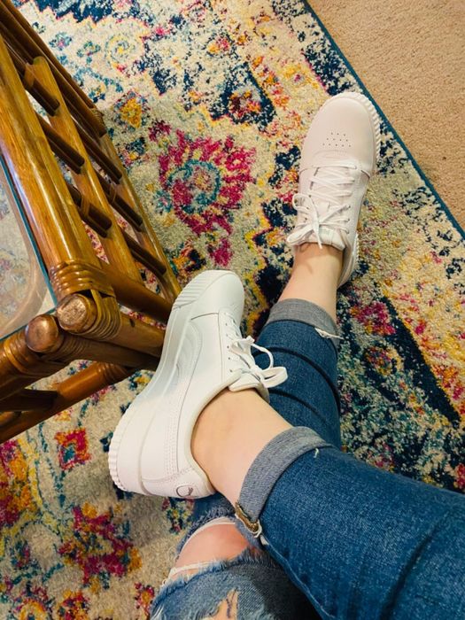 close-up shot of the reviewer wearing the sneakers paired with ripped jeans