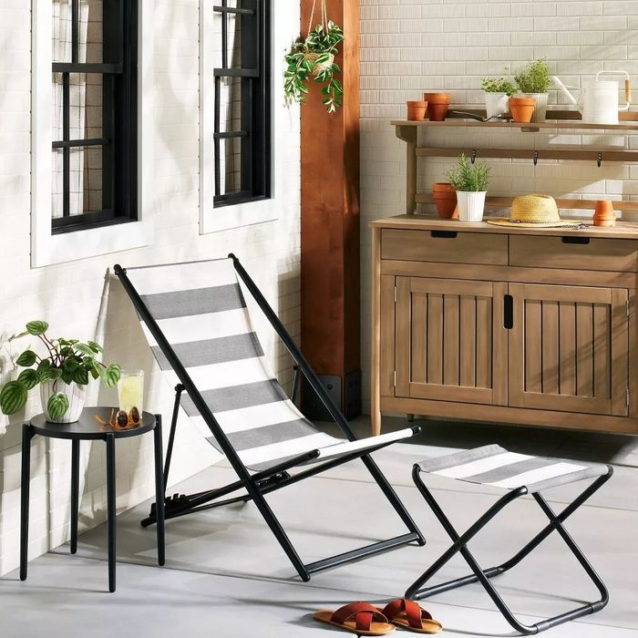 A chair with a matching ottoman (sold separately) placed on a deck