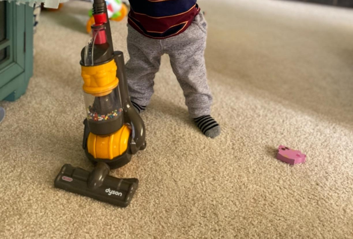 A photo from the reviewer showcasing their child using the vacuum