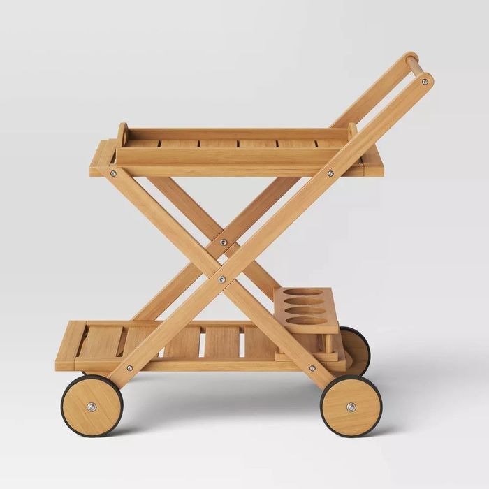 A wooden bar cart on wheels