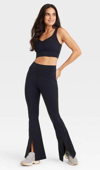 Model wearing black split-hem yoga pants.