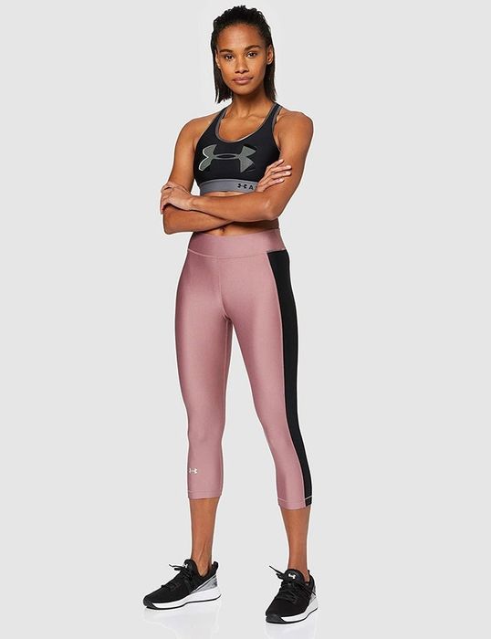 A model demonstrates Under Armour HeatGear leggings in action.