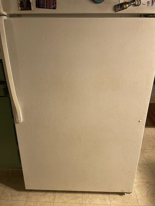 A closed white refrigerator door in a kitchen with several magnets decorating the top edge. This image falls under the Shopping category.