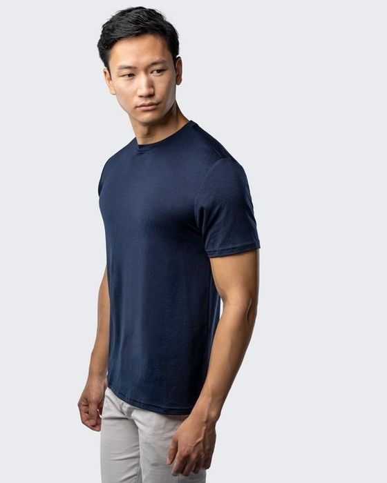 The model wears a crewneck tee.