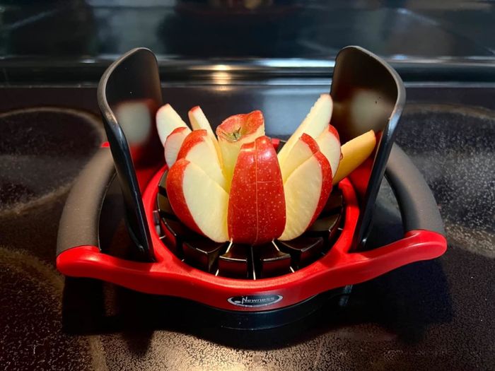 A reviewer's photo of an apple precisely sliced with an apple slicer equipped with handles