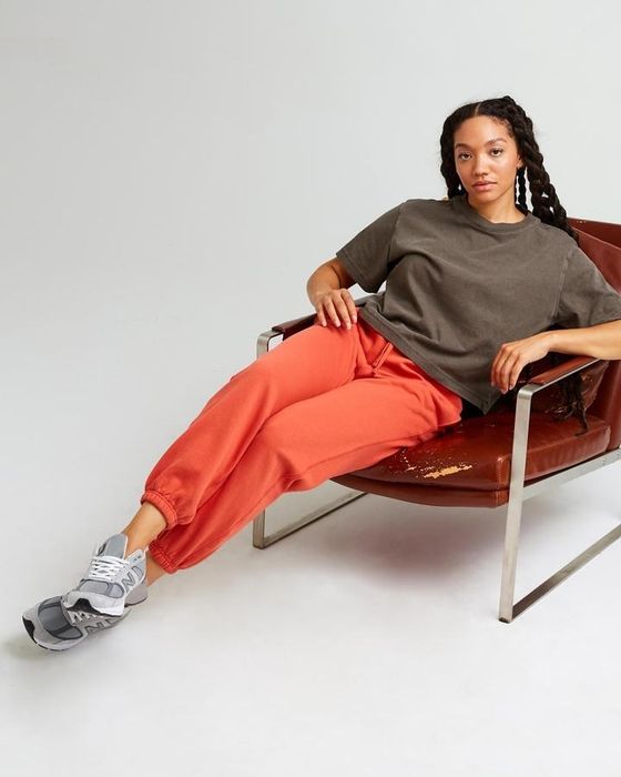 The model wears sweatpants with elasticized bottoms.