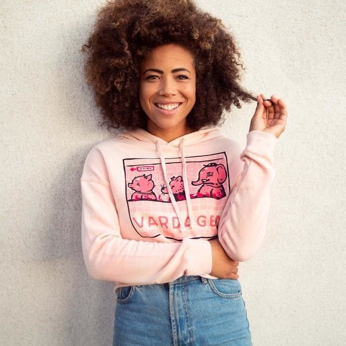 The model wears a pink hoodie with an illustration of animals waiting in line.