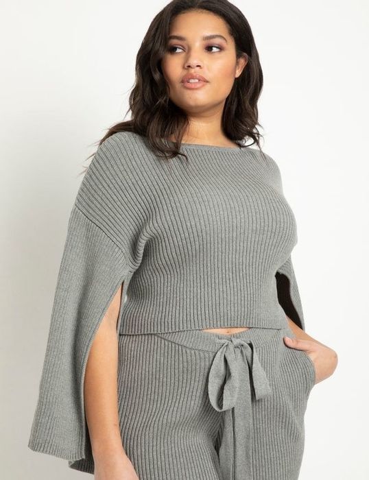 The model wears a cropped ribbed sweater with split sleeves.