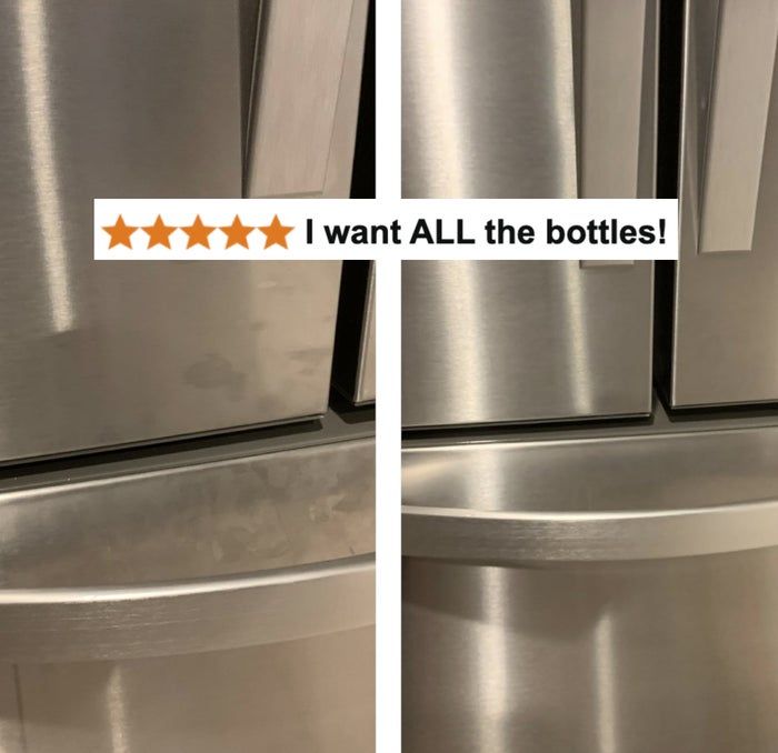 A close-up shot of a stainless steel refrigerator's lower door and drawer handles in a retail setting. No text or people are visible.