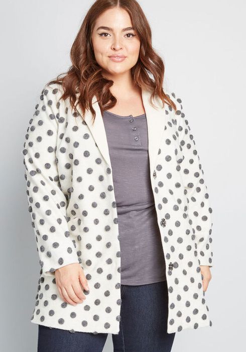 A white coat featuring grey polka dots.