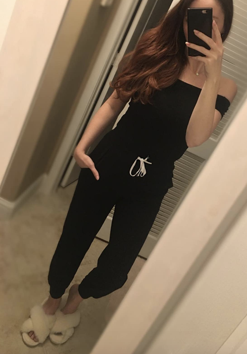 The reviewer is wearing a black jumpsuit.