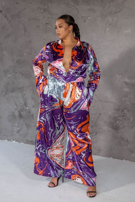 Silky pants with a vibrant swirl design in orange, grey, and purple hues.