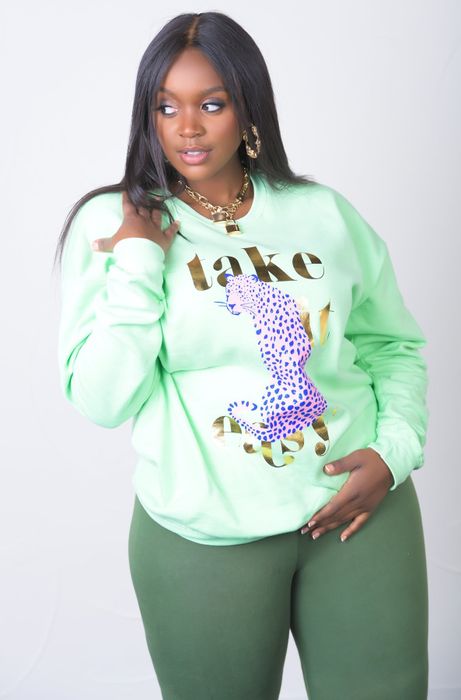 A model is seen wearing a sweatshirt featuring a cheetah cartoon and the phrase 'take it easy.'