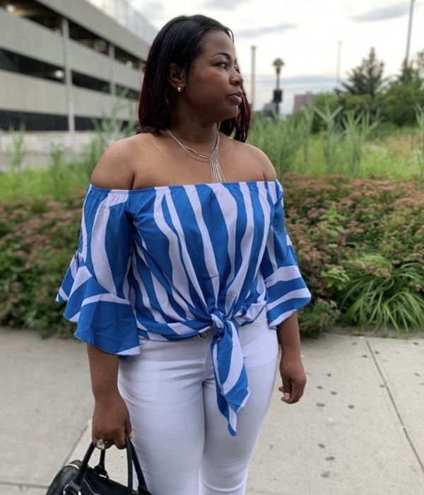 A person wearing a blue and white striped top paired with white pants.