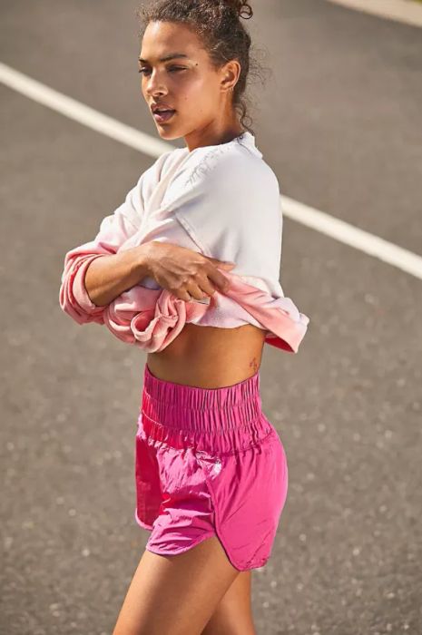 a model showcasing the high-waisted shorts in a vivid pink shade