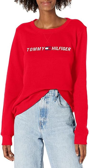 A model is sporting a sweatshirt with the Tommy Hilfiger logo prominently displayed.