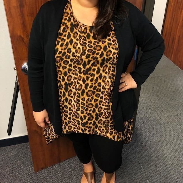 A reviewer wearing the cardigan in black, paired with leggings and a leopard print top.