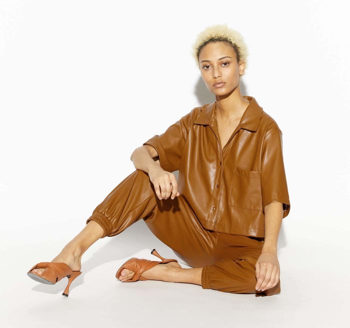 A model is wearing the cropped shirt with matching tights.