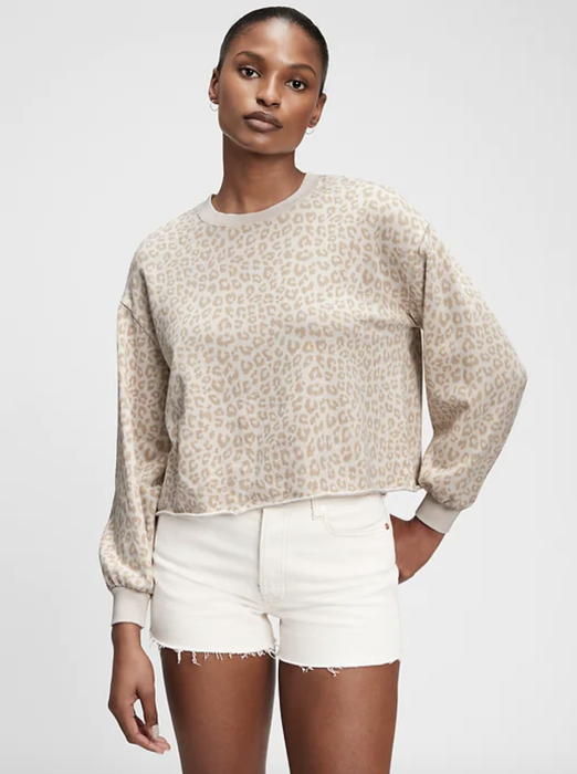 A model is seen wearing a beige and white leopard print sweatshirt.