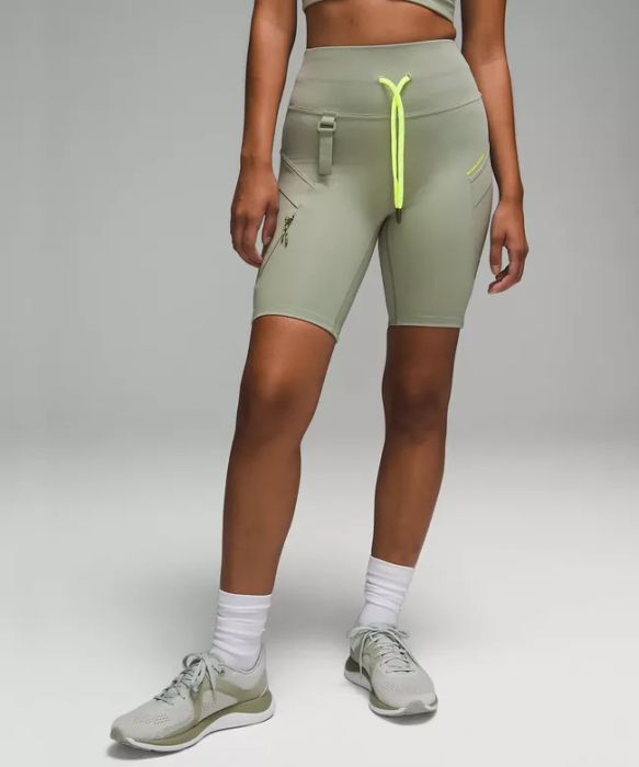 a front-facing image of a model wearing shorts with neon accents