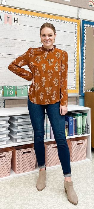 A reviewer wearing the blouse in brown