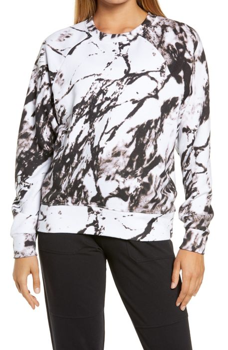 A model is seen wearing a white and black marble print sweatshirt.