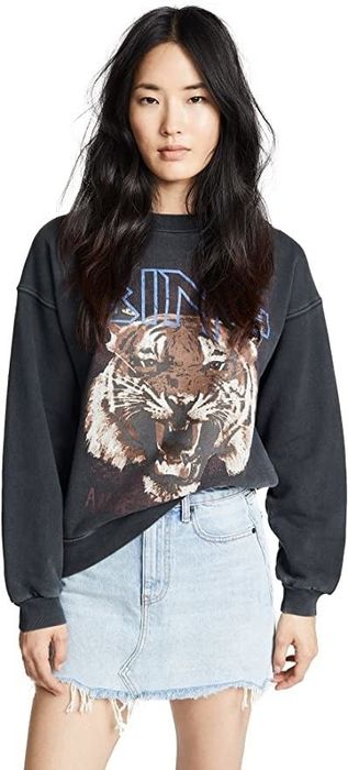 A model is seen wearing a sweatshirt with a tiger graphic on it.