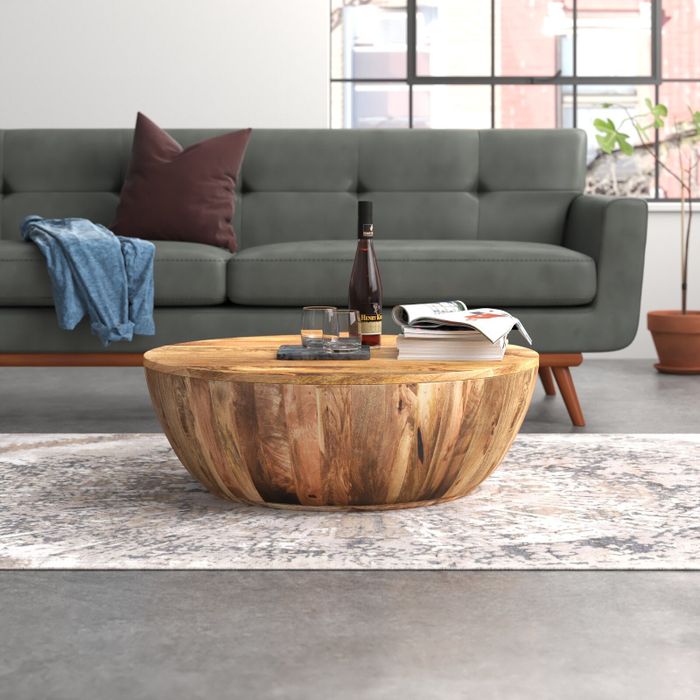 Image of a brown wood coffee table with wine glasses and books on it