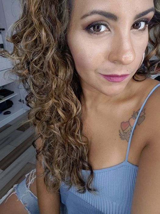 A customer proudly displays her soft and shiny curly hair after using the Moroccan Argan Oil Shampoo and Conditioner.