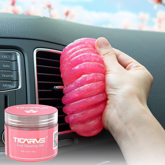 A model demonstrating how to use hot pink gel to remove dust from car air vents.