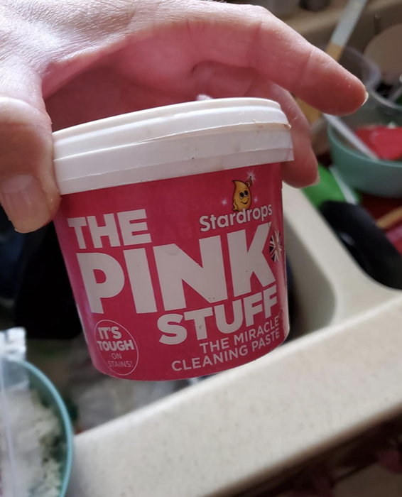 Image of a reviewer showcasing the iconic pink jar of cleaning paste.
