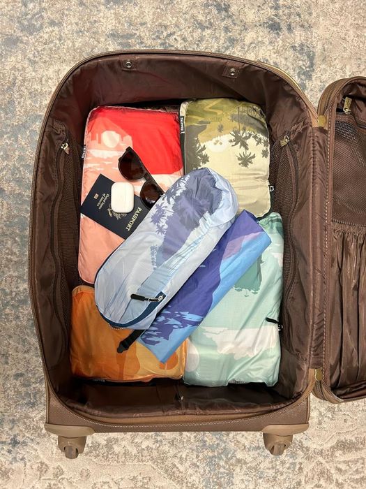 Colorful packing cubes arranged in a reviewer's suitcase.