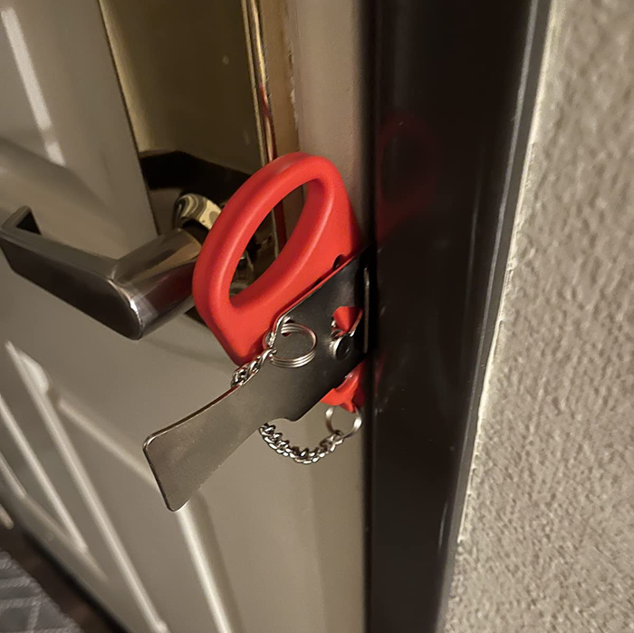 a red portable lock secured in a door jamb to prevent it from being opened