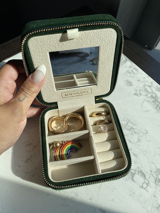 A reviewer's green velvet jewelry case, containing two pairs of earrings and three rings.