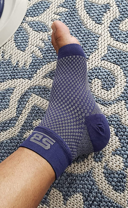 A reviewer wearing blue compression socks.