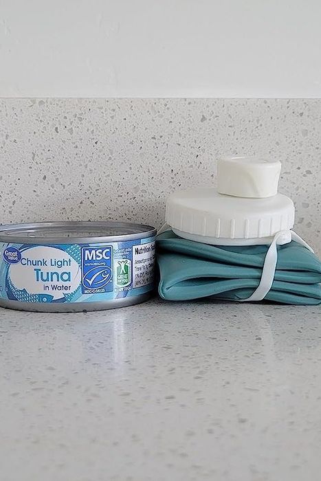 The water bottle folded down beside a can of tuna