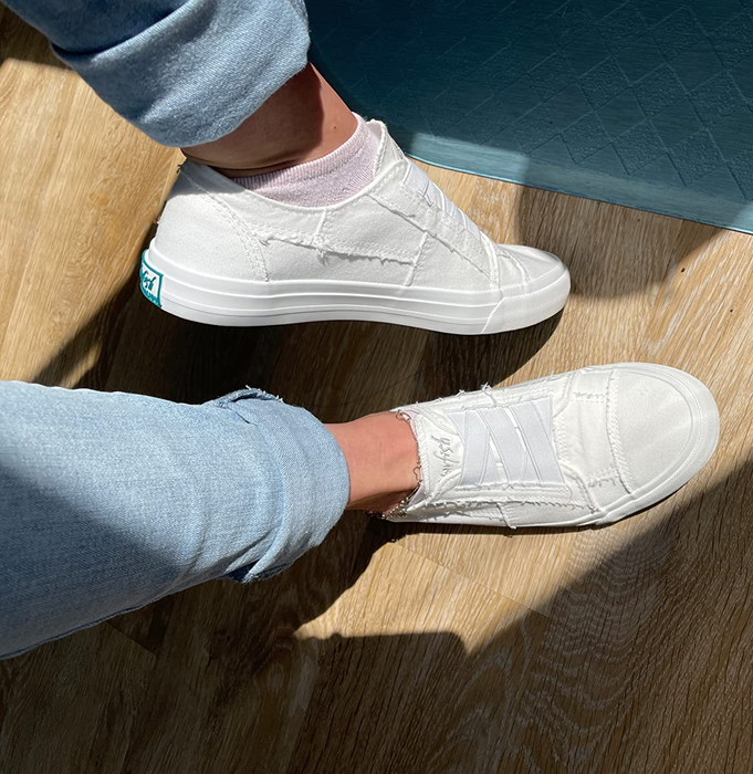A reviewer wearing the white Blowfish sneakers.