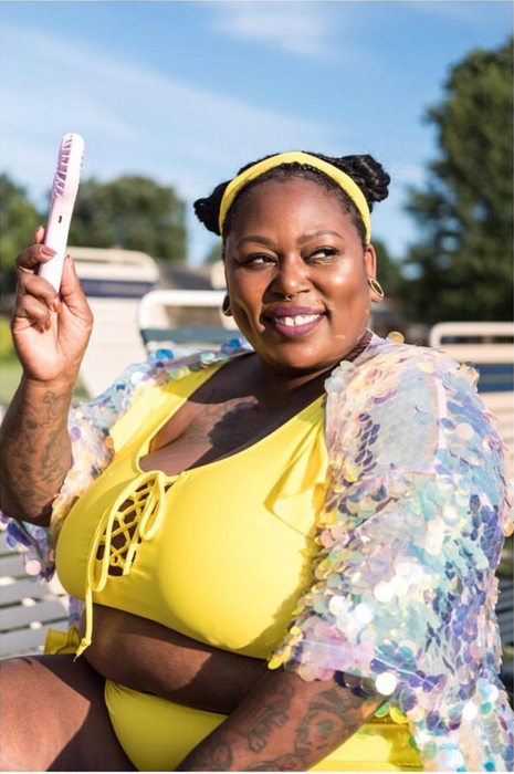 a reviewer showcasing the pink handheld fan