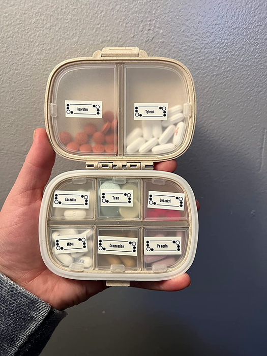 A reviewer displaying their pill organizer, filled with pills and labeled compartments.