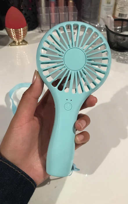 a reviewer holding the blue fan in hand