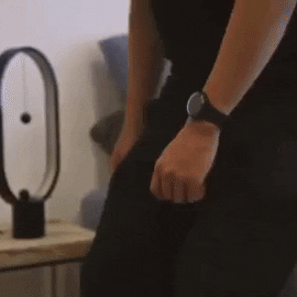 An individual using two magnetic spheres, connected by strings, to activate the lamp
