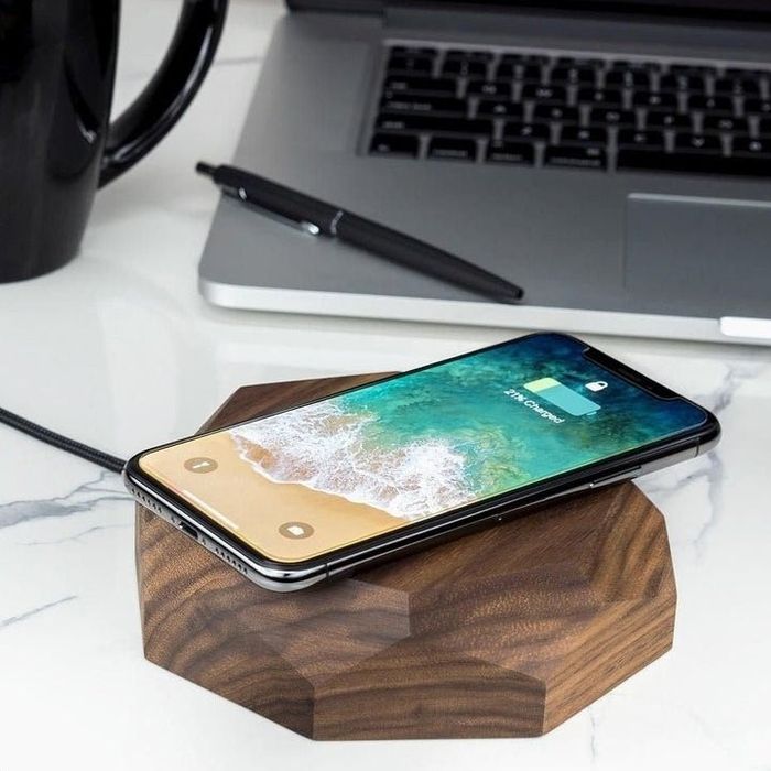 a wooden wireless charger with an iPhone placed on it