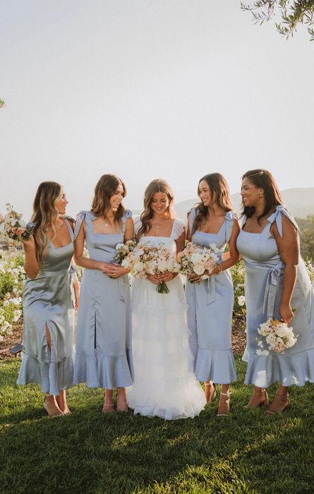 A group of bridesmaids dressed in the blue dress.