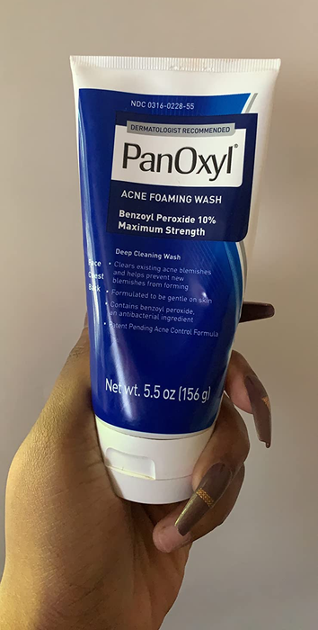 A reviewer holding their bottle of PanOxyl Acne Foaming Wash